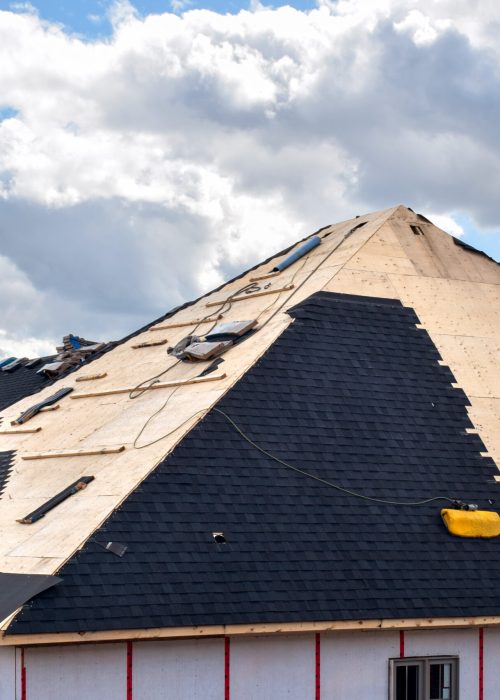 The process of installation of black roof shingles on new residential home